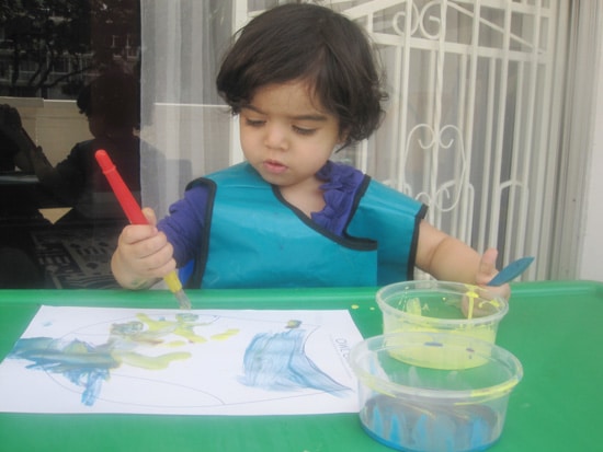 toddler painting on a piece of paper 