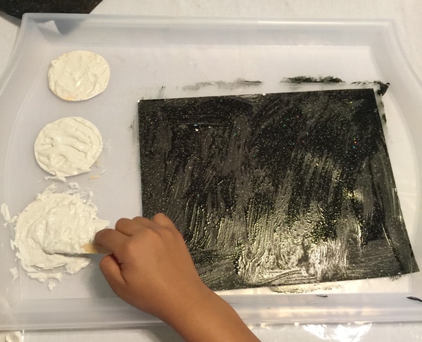 Creating a realistic looking moon with the kids by adding flour to white paint