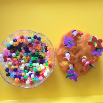 Spring play dough flower activity focuses on fine motor skills through the use of play dough