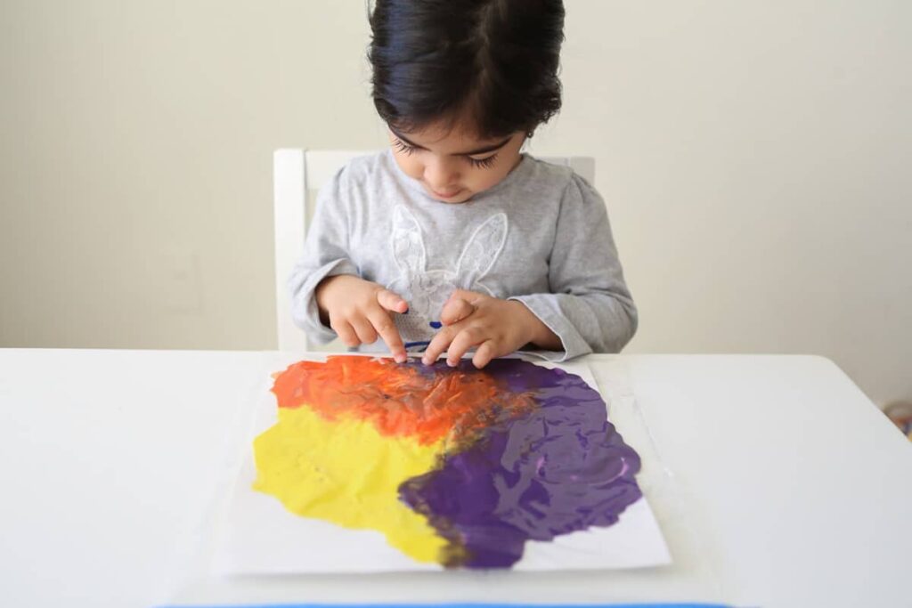 toddler finger painting on paper 