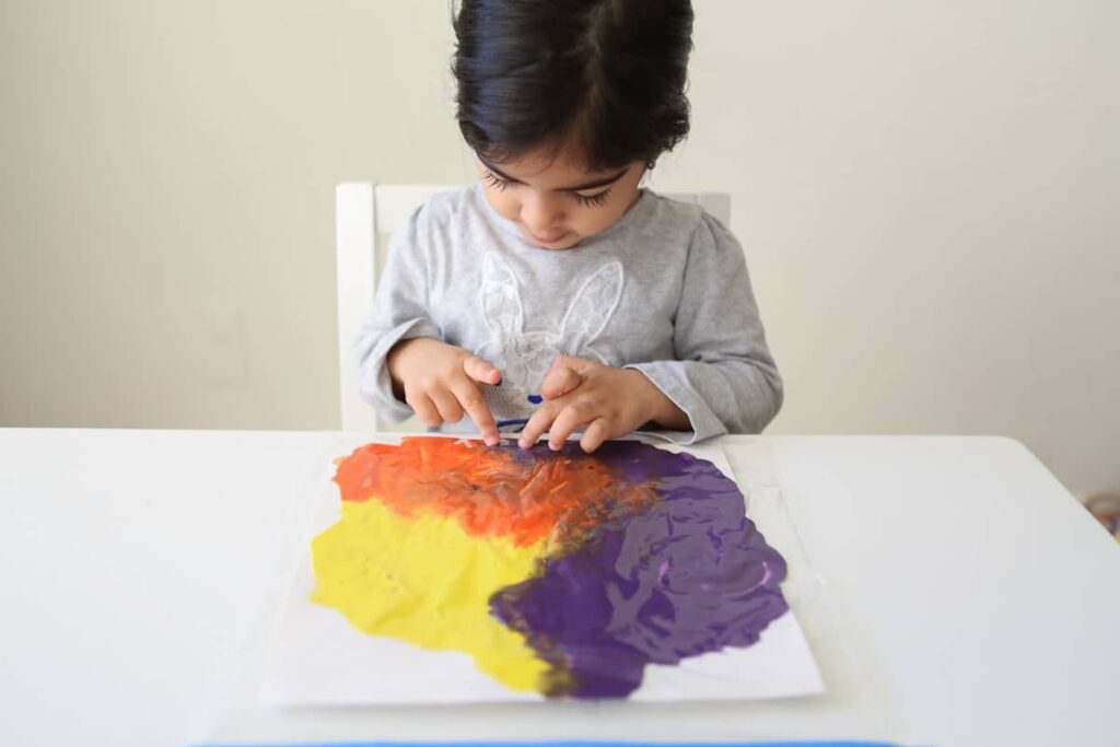 toddler finger painting on paper