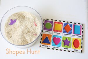 Toddler learning shapes through sensory bin rice hunt