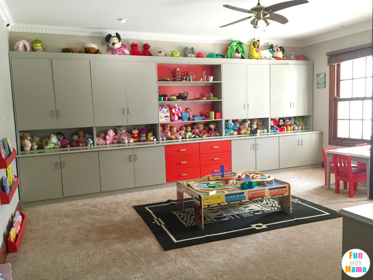 a grey and red child's playroom that features a train table and toy storage.