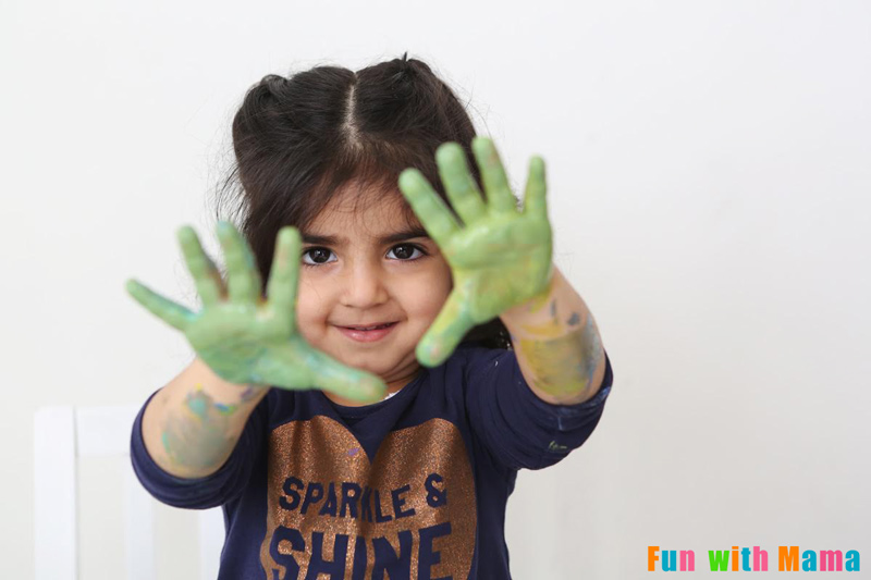 toddler with hands painted