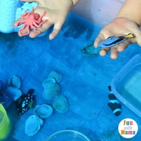 under the sea sensory bin examining the fish (Small)