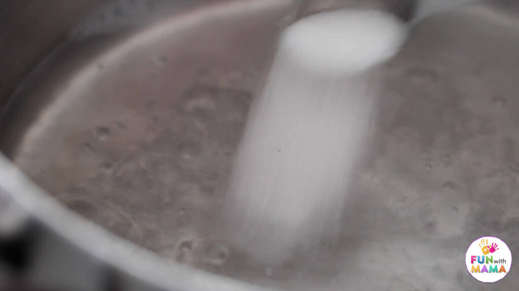 Adding sugar to boiling water on the stove