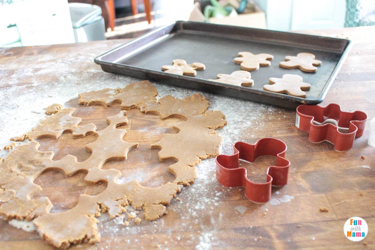 using gingerbread cookie cutters to cut out the cookies 