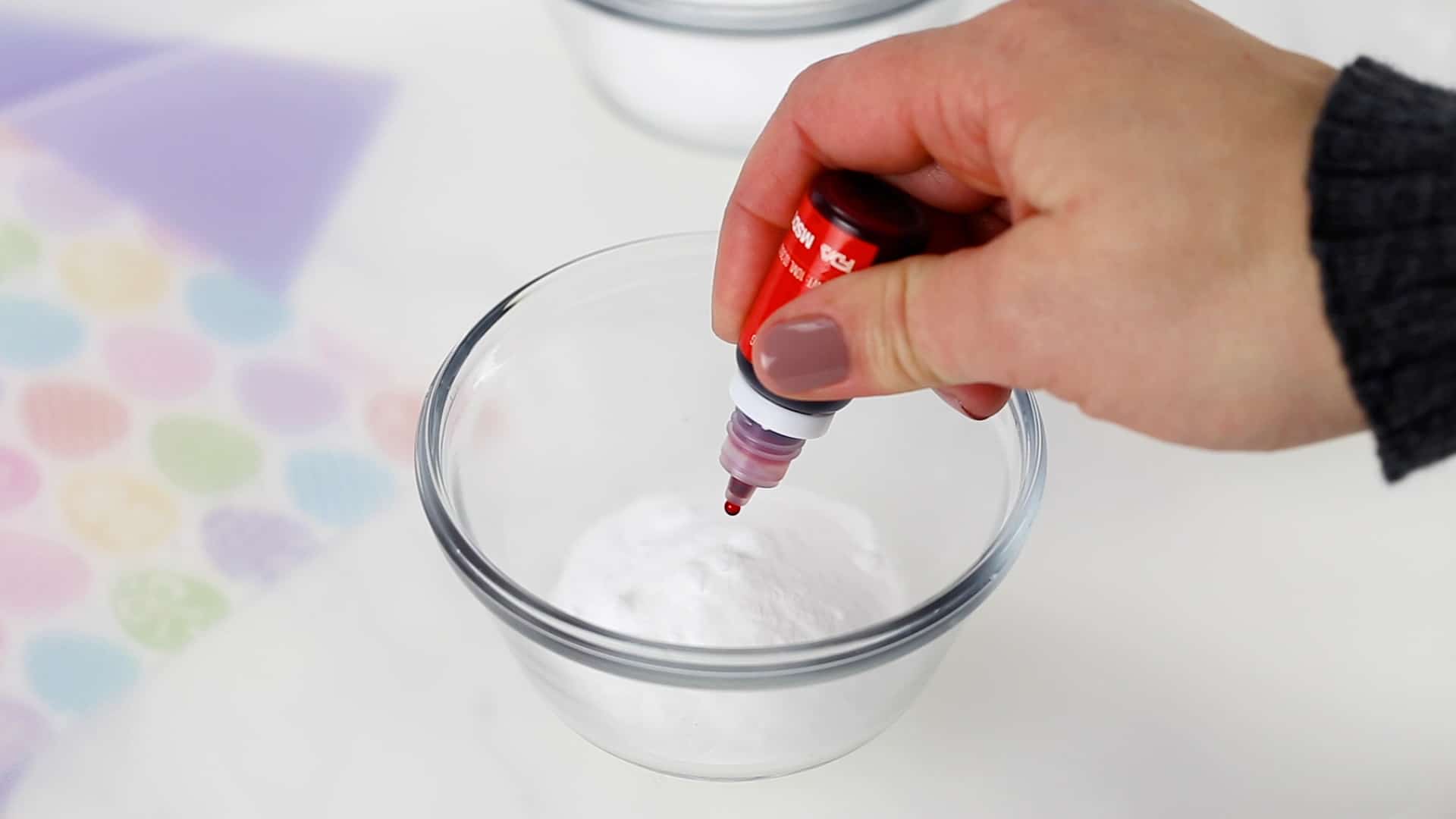 adding baking soda and gel to cup to dye Easter eggs