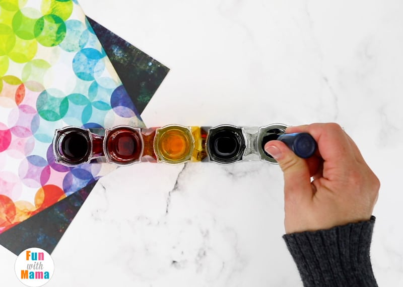 adding food coloring drops into the water in the vase