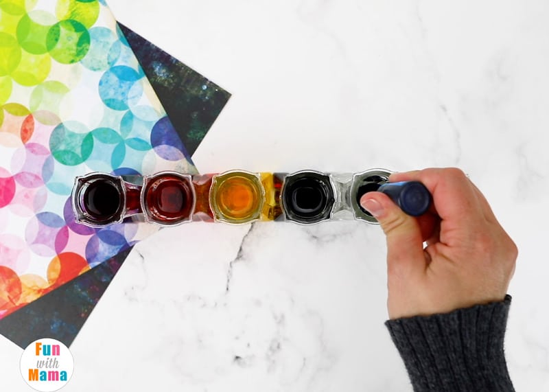 adding food coloring drops into the water in the vase 