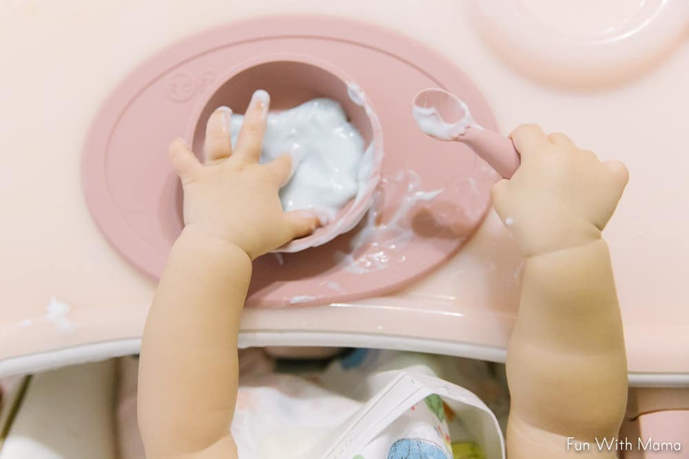 one year old hands playing with yogurt