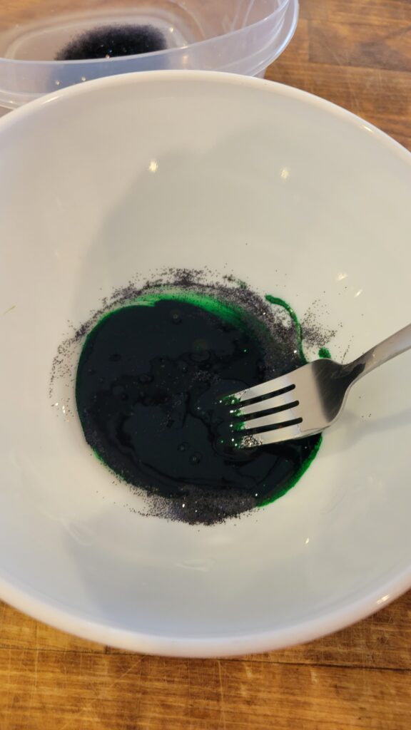 stirring the food coloring into the slime ingredients 