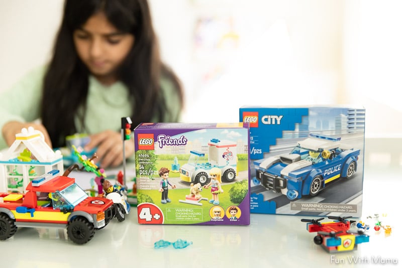 girl playing with boxed lego sets 