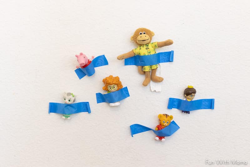 toys taped on the wall for fine motor play 