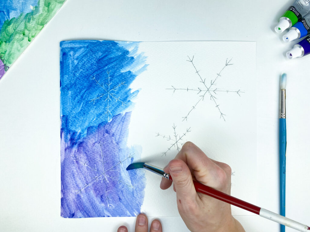painting the paper with watercolor paints