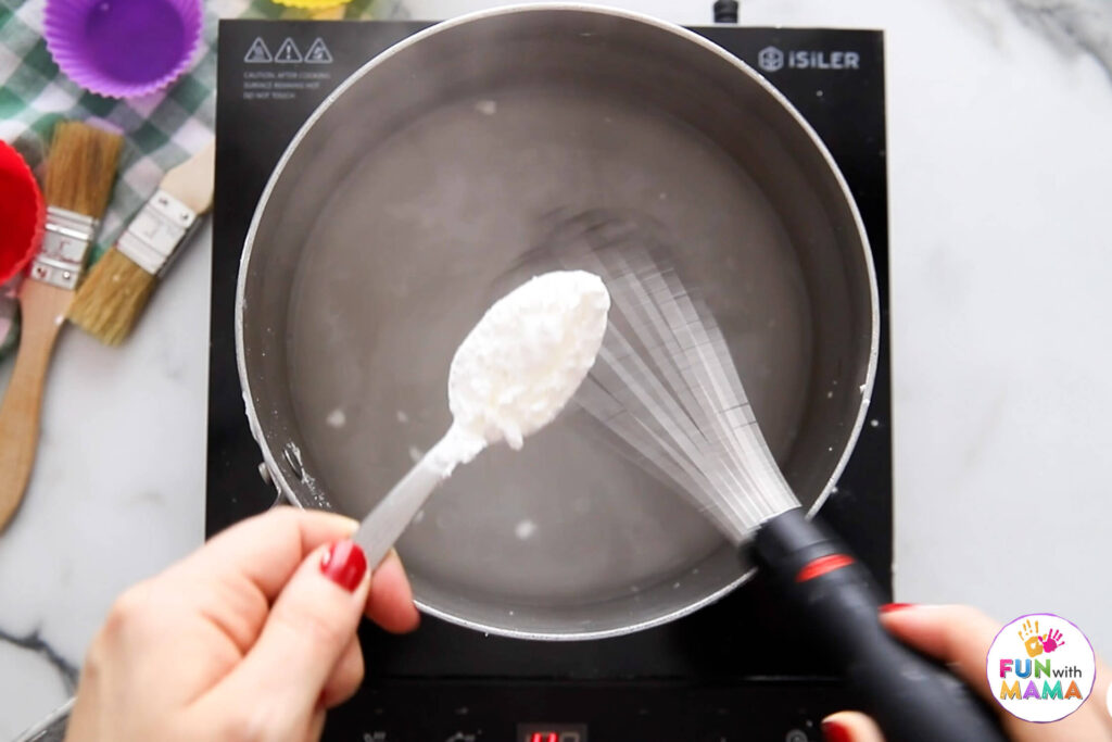 Putting in cornstarch to boiling water pot on stove
