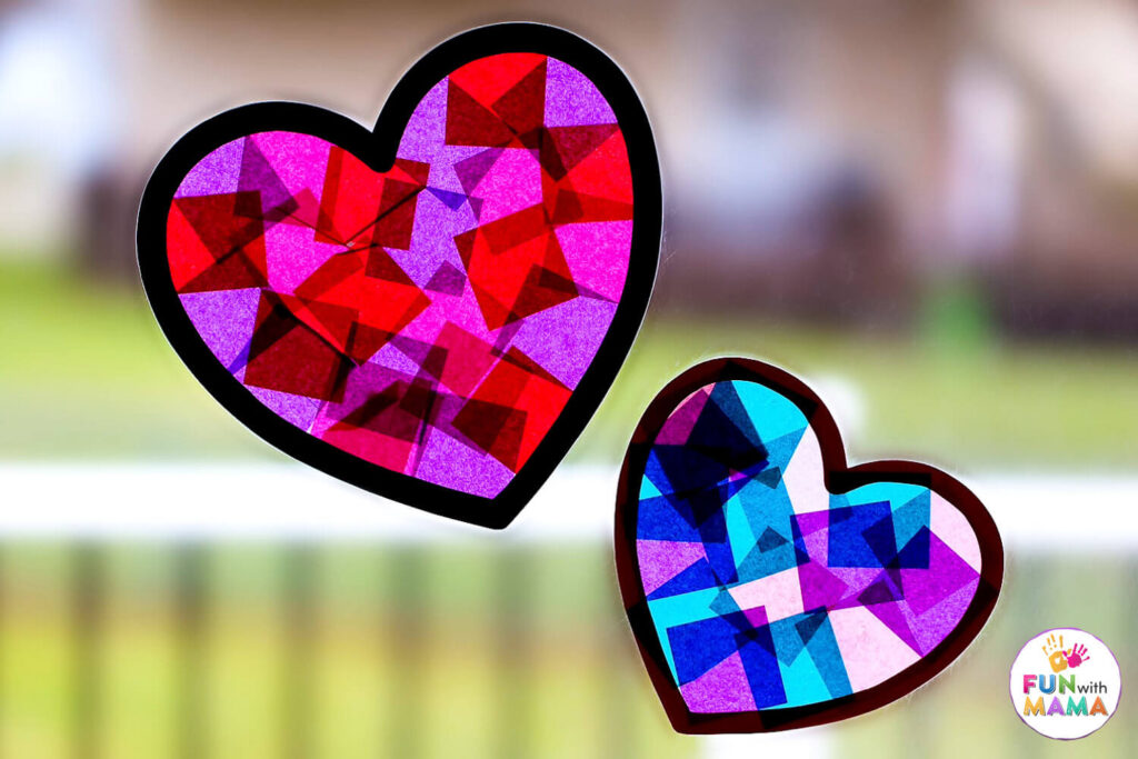 2 completed heart suncatchers filled with blue, purple and red tissue paper squares stuck on a window