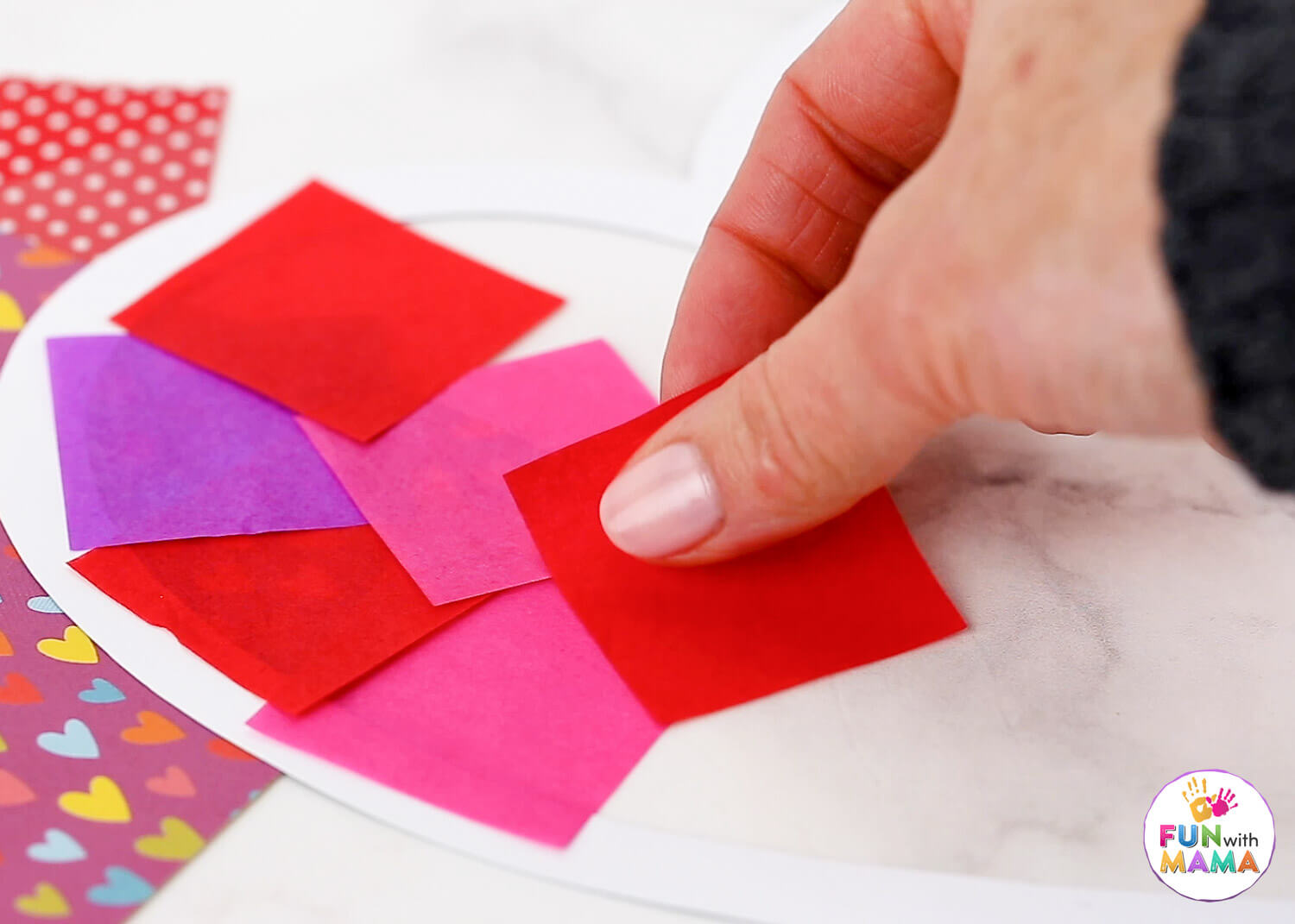 Red, pink and purple tissue paper squares placed in an alternating pattern inside the heart frame